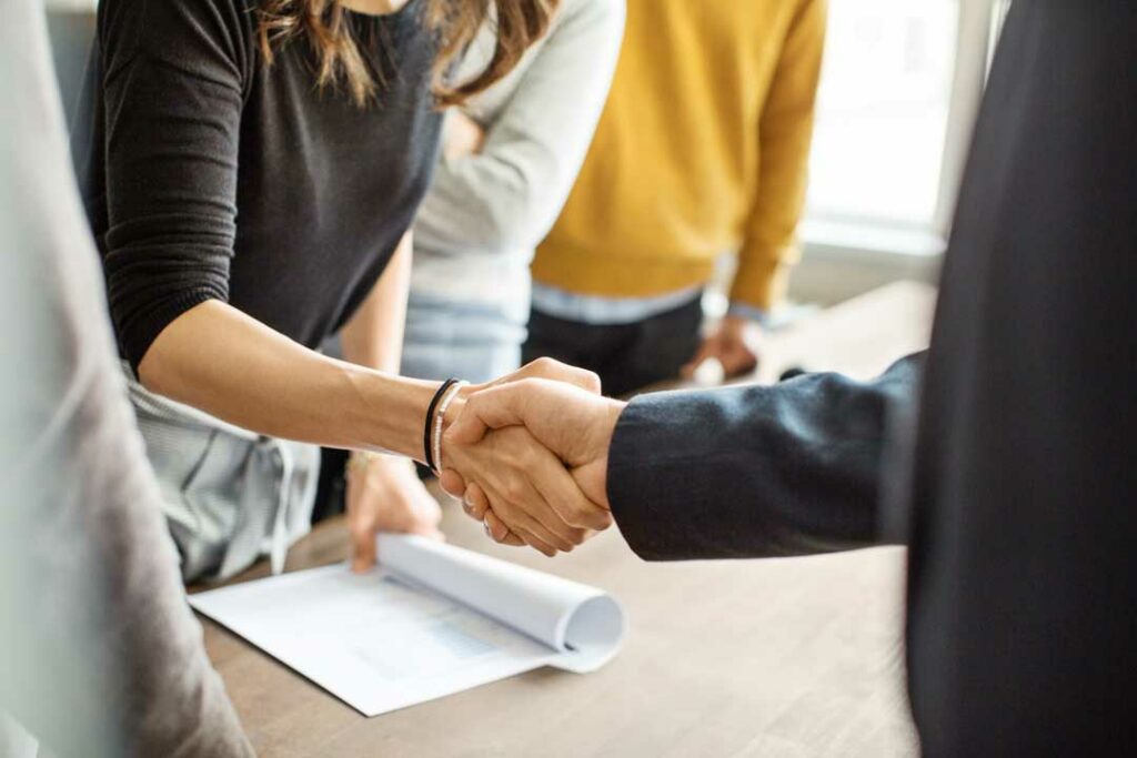 A handshake between a man and a woman in a business environment